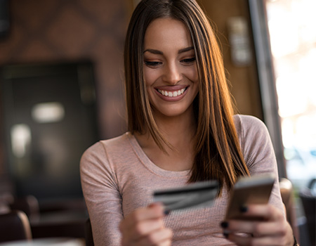 Woman holding a phone and a credit card