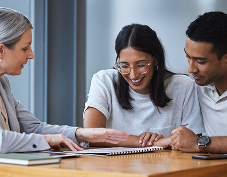 Happy couple looking at paperwork with a consultant